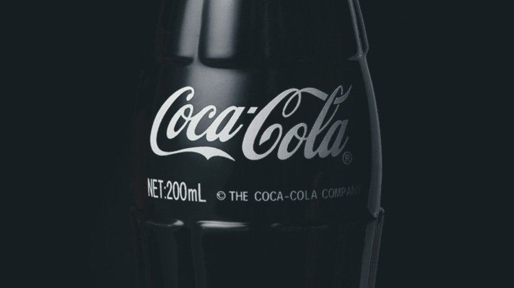Garrafa da Coca-Cola em contornos discretos em fundo escuro.